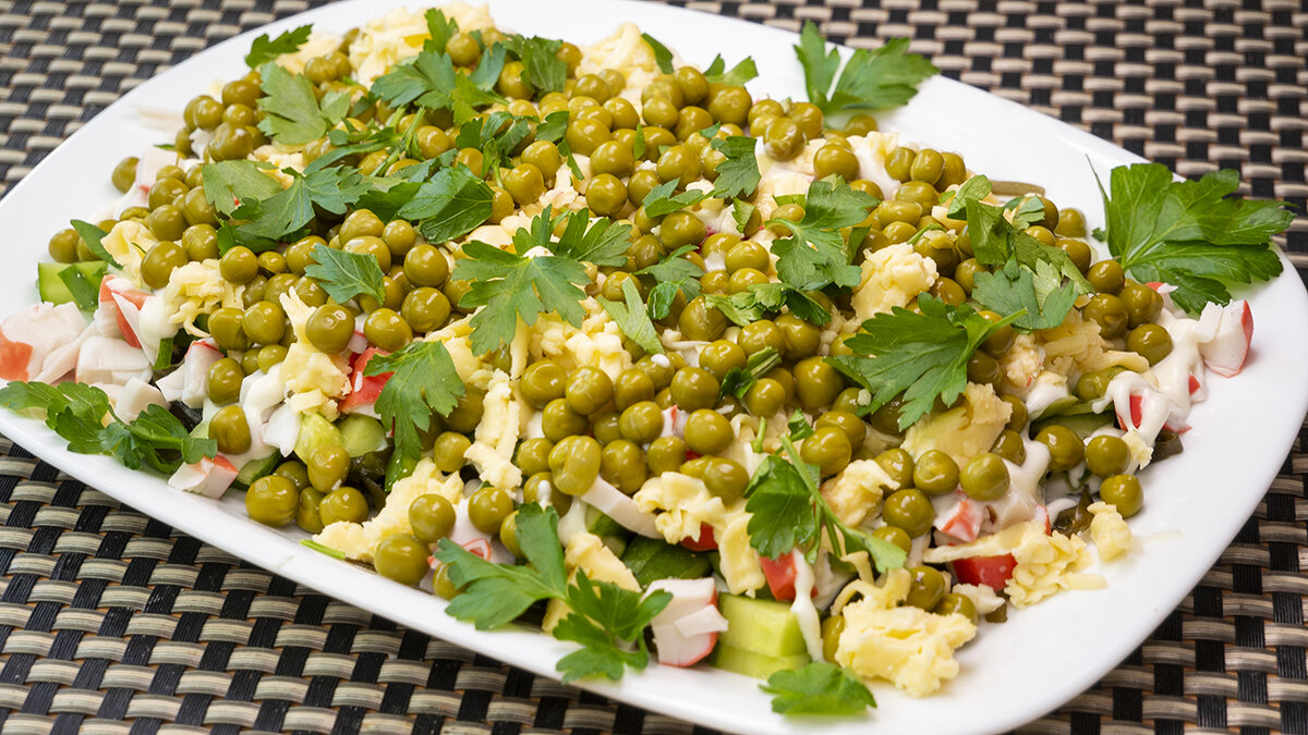 Слоёный салат с морской капустой, горошком и крабовыми палочками.