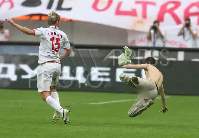 Игрок Московского Спартака Ковач сбивает с ног выбежавшего на поле болельщика