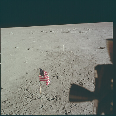 Космонавты снимают флаг из лунного модуля.