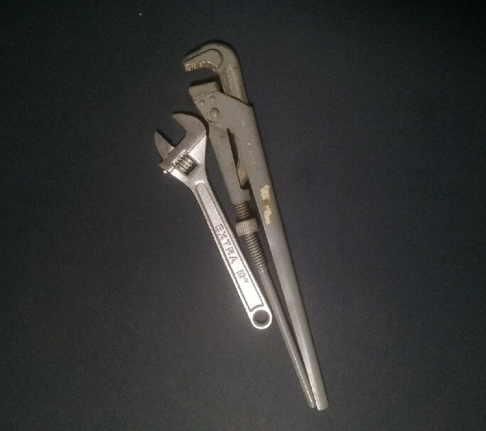 Разводной и газовый ключи справятся с запорными гайками на старой батарее за несколько минут.