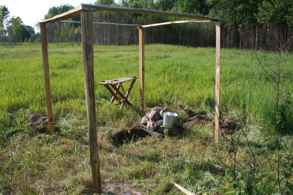 Выкопали яму под костёр, сверху выложили камни, поставили ведро с водой.