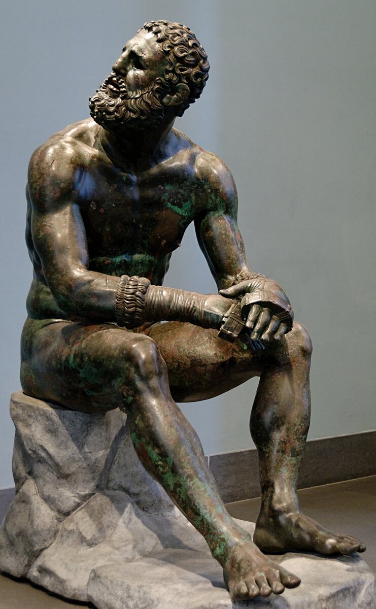 So-called “Thermae boxer”: athlete resting after a boxing match. Bronze, Greek artwork of the Hellenistic era, 3rd-2nd centuries BC (the boulder is modern and replicates the ancient one). From the Thermae of Constantine.