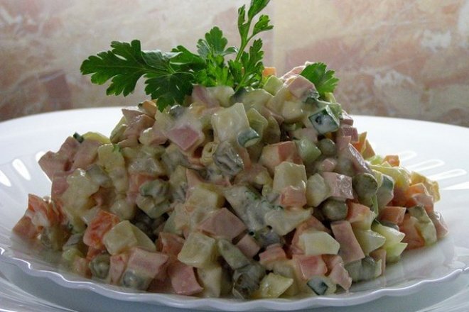 Ингредиенты:  
Вареная колбаса (ветчина) - 200-250 г
Морковь - 1 шт.
Картофель - 3-4 шт.
Зеленый горошек - 1 банка
Огурцы соленые (маринованные корнишоны) - 3-4 шт.
Лук - 1 шт.(средняя луковица)
Вареное яйцо - 3-4 шт.
Соль, черный молотый перец
Майонез - 100-150 г