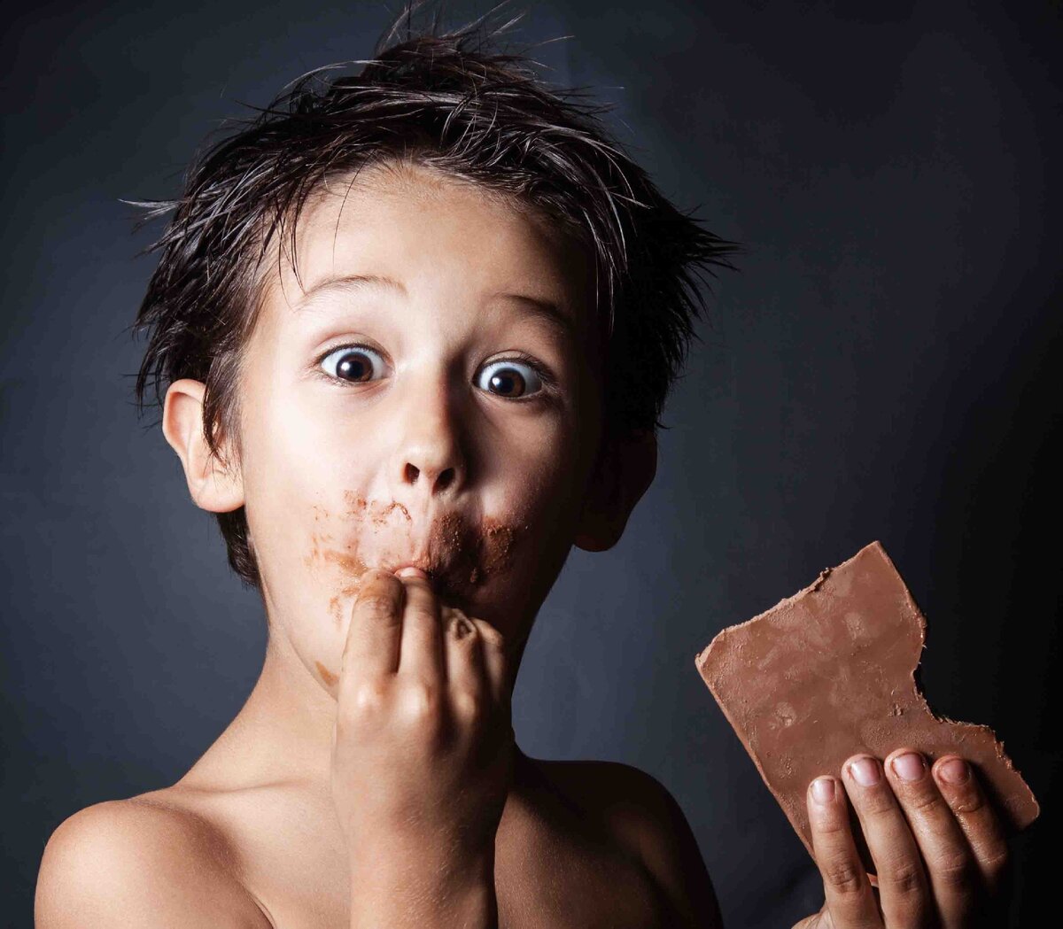 Мальчик с шоколадкой. Мальчик ест шоколад. Поедание шоколада.