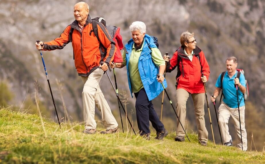 Небольшая группа любителей скандинавской ходьбы на прогулке