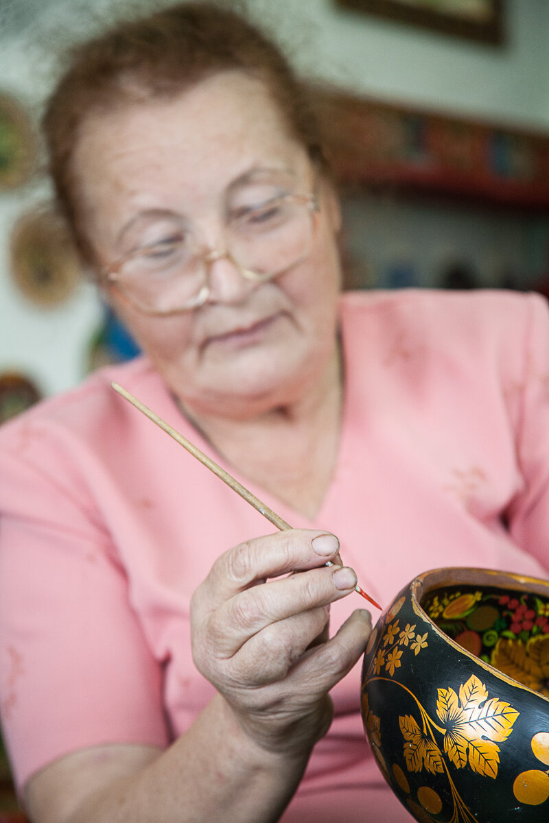 У Александры Ануфриевой после закрытия фабрики сохранились неоконченные изделия. На них она наглядно показывает этапы хохломской росписи