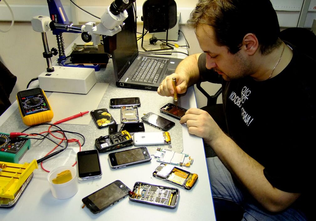 Мастер за ремонтом смартфонов. Фото из свободного доступа Яндекс.Картинки.