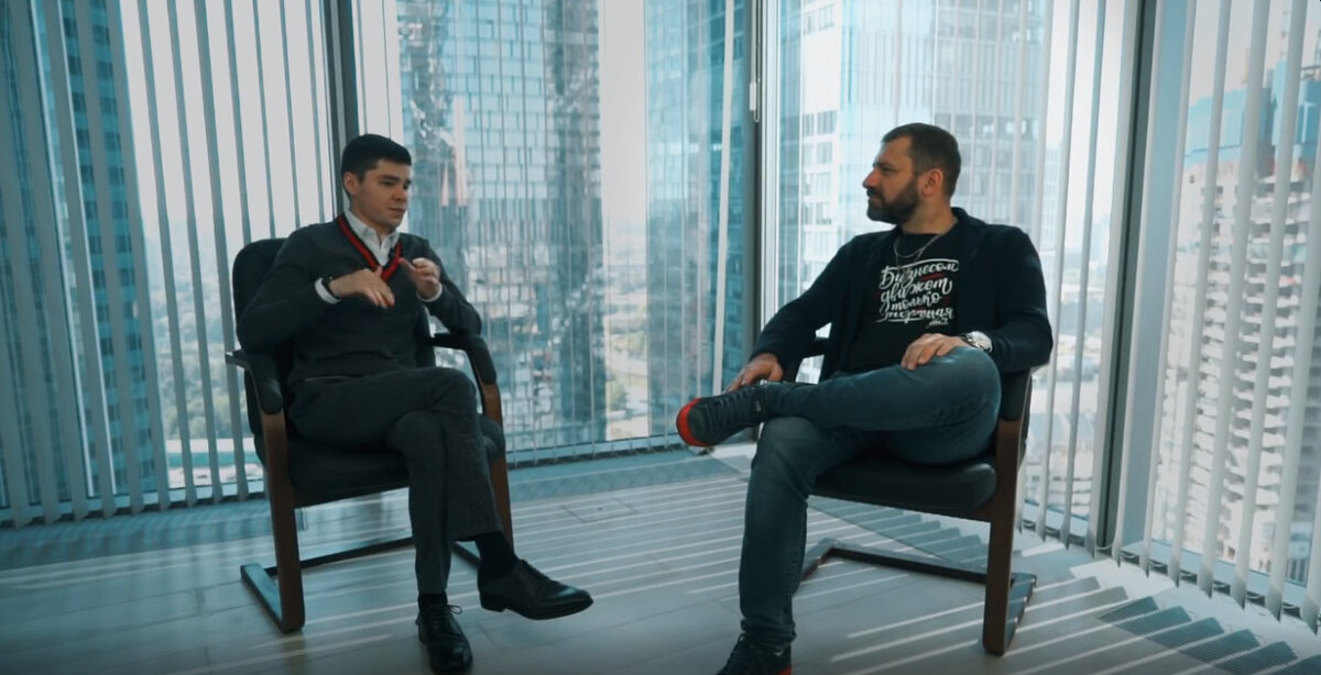 Интервью у Игоря Рыбакова. Стиль «хорошего мальчика» на Аязе в сочетании со слабой «сжатой» позой «нога на ногу», тогда как у Рыбакова поза «американская четверка» вызывающая и доминирующая.