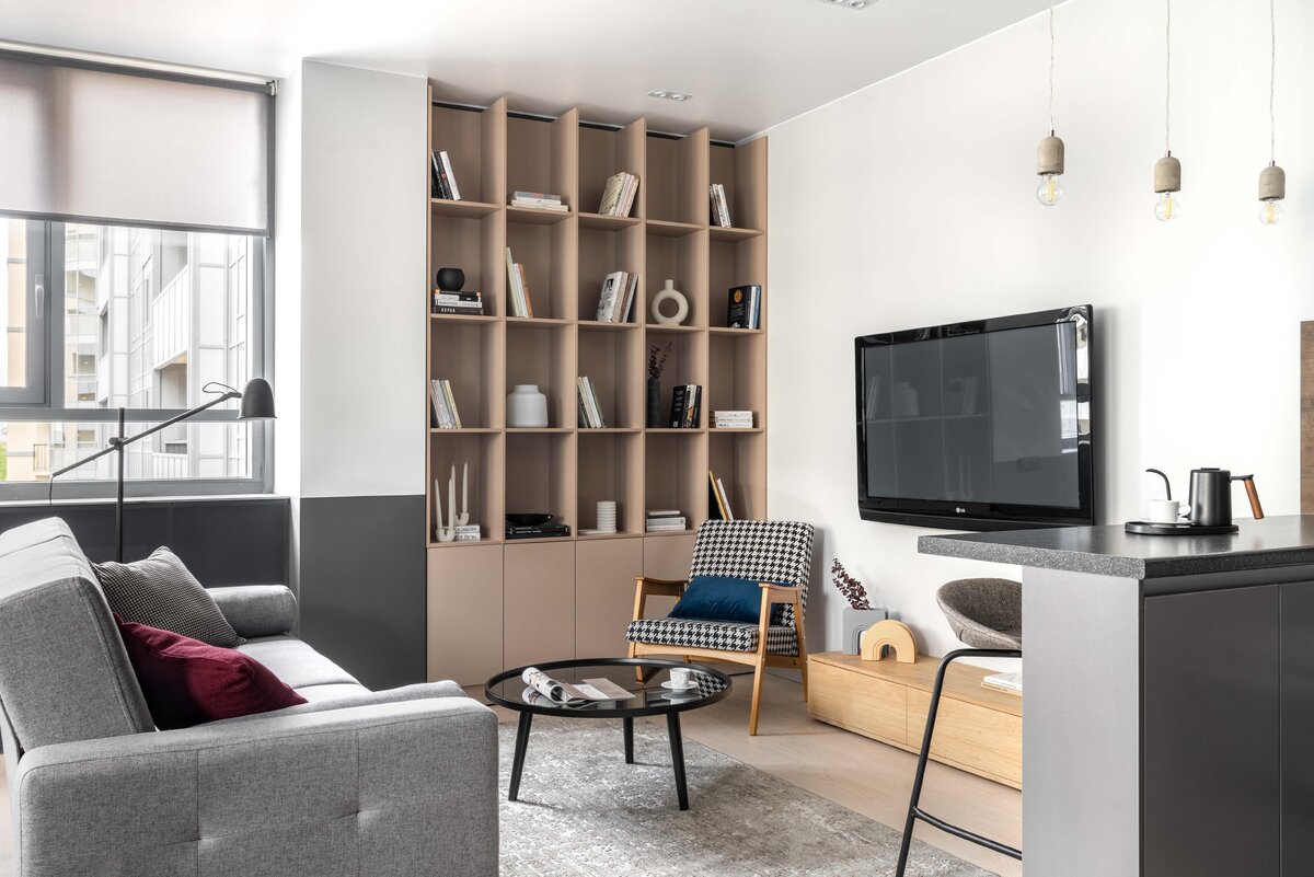    Гостиная. На полу — ламинат, Quick Step. На стенах — краска, Dulux. Стеллаж выполнен на заказ, ИП «Орехов Р.В.». Кресло, Vintastica. Журнальный столик, «Огого обстановочка!». ТВ-тумба, Osobica. Ковер, Leroy Merlin. Диван, Hoff. Барные стулья, Sheffilton. Подвесные светильники, Eglo. Встроенные светильники, Lightstar. Торшер, ИКЕА., фото: Андрей Семенов