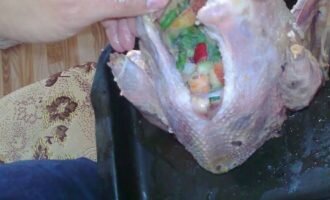 Яблоки, картофель и лук мелко нарезают. Помещают внутрь птицы.