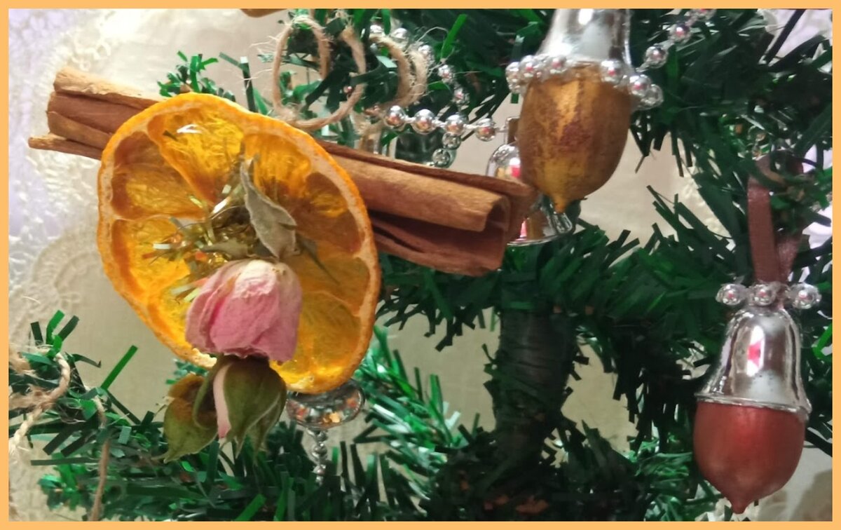 Кружок мандарина с розочкой на палочке корицы.