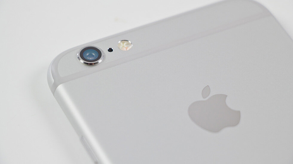 iPhone 6 невероятно популярен в России, купить iPhone 6 32 Гб можно за 18 990 руб.
Представленный осенью 2014 года iPhone 6 наделал много шума. Еще бы, ведь Apple отказалась от заветов Джобса и переключилась на производство смартфонов с большими дисплеями. Большой 4,7-дюймовый дисплей отпугнул часть поклонников техники Apple, однако большинство столь кардинальным изменения оказались рады, благодаря чему iPhone 6 стал самым продаваемым смартфоном в мире, установив практически недосягаемую планку по количеству продаж. Но неужели iPhone 6 стал хитом только благодаря дисплею? Нет, нет и еще раз 20 (на каждую уникальную особенность смартфона) нет. iPhone 6 поразил по всем фронтам.Комплект поставки
Начнем с обыденных вещей — упаковки и комплекта поставки iPhone 6. Коробка смартфона, как и сам аппарат, получила обновленный дизайн. Начиная с «шестерки» упаковка стала белой. На верхней грани выштампован смартфон, сбоку лаконичная надпись «iPhone» и логотип Apple. По давней традиции Apple всё просто и очень стильно — такую коробку смартфона вряд ли кому-то захочется выкинуть.
Комплект поставки самый что ни на есть обычный. Вместе с iPhone 6 поставляются наушники EarPods, блок питания, кабель USB, скрепка для извлечения SIM-карты и документация. Впрочем, ожидать чего-то особенного в комплектации и не приходилось.
Дизайн
Смартфон получил большой 4,7-дюймовый дисплей и цельный алюминиевый корпус, оказавшись совершенно непохожим на предыдущие модели iPhone. Особенно впечатляет корпус устройства. Когда держишь iPhone 6 возникает ощущение того, что смартфон является полностью цельным — до такой степени искусно выполнен переход между алюминиевой задней частью и передним стеклом. Благодаря умело выполненному переходу и несколько скругленным торцам, iPhone 6 очень легко поднимать с любых ровных поверхностей. Боковые рамки вокруг дисплея уменьшены — до нулевых показателей им, конечно, далеко, но назвать толстыми их ну никак нельзя.Единственные спорные моменты ожидают на задней стороне iPhone 6. Во-первых, это полоски антенн (которые видно и сбоку), расположенные сверху и снизу. Многим они жутко не нравятся, но если отбросить все эмоции, то ничего уродливого в них точно нельзя разглядеть. А во-вторых, камера iPhone 6 немного выпирает из корпуса. Опять же, такая практика среди производителей смартфонов вполне стандартная, а главное — оправданная. Если не увеличить размер модуля камеры, то качество съемки значительно повысить бы точно не удалось.Размеры iPhone 6 составляют 138,1×67×6,9 мм, вес — 129 грамм. Сразу же необходимо ответить на главный вопрос пользователей предыдущих моделей iPhone — удобно ли пользоваться «шестеркой» одной рукой? Здесь всё зависит от рук. Если у вас небольшие или даже среднестатистические руки, то приготовьтесь браться за iPhone 6 двумя руками — только так смартфоном получится орудовать быстро и непринужденно. Людям же с большими руками подобных проблем не познать (только если вы намерены купить 5,5-дюймовый iPhone 6 Plus).
 