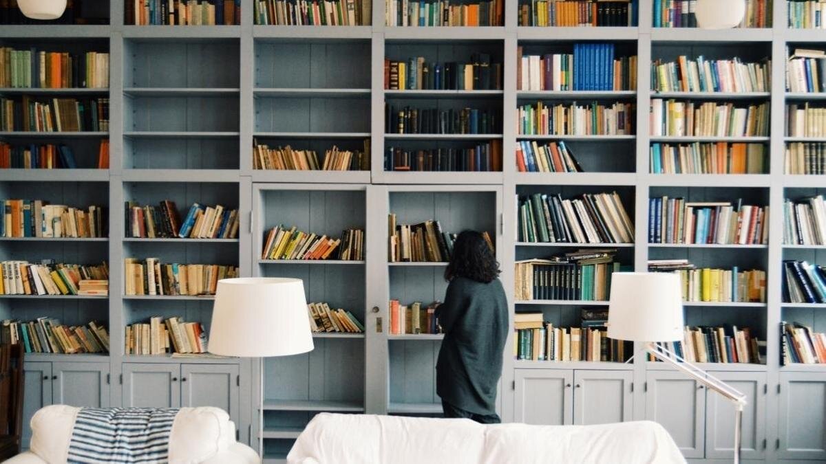    Женщина выбирает книги у стеллажей:Unsplash/Radu Marcusu