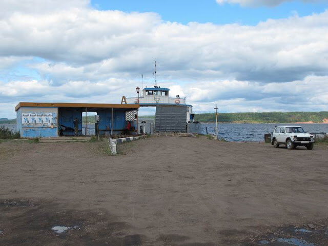 Вот так выглядит место швартовки парома и погрузки на него транспорта. Из береговых сооружений только обыкновенная автобусная остановка с приклеенным листком расписания движения парома.