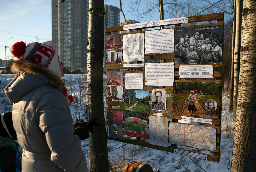 Стенд с фотографиями у дороги.
