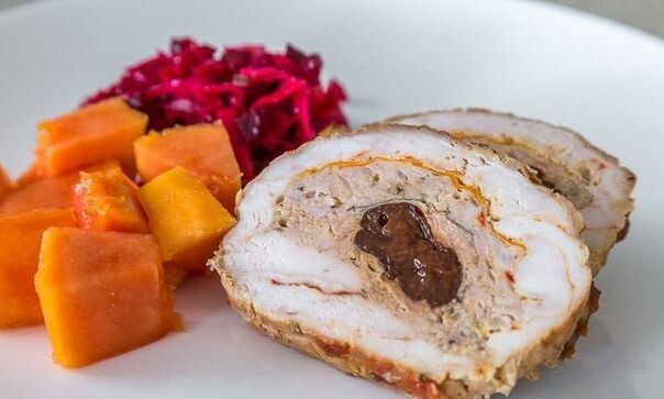 ​​Куриный рулет  
Ингредиенты:

Куриное грудка с кожицей — 3 шт.
Куриный фарш — 500 г
Лук-порей — 1 шт.
Луковица — 1 шт.
Яйцо — 1 шт.
Морковь крупная — 1 шт.
Чернослив — 200 г
Оливковое масло — 2 ст. л.
Соль — по вкусу 
Специи (перец, острый соус, веточка тимьяна и т. д.) — по вкусу 

Приготовление:

1. Луковицу и лук-порей вымойте, обсушите и нарежьте.
2. Разогрейте на сковороде ложку растительного масла и обжарьте два вида лука до мягкости.
3. Вымойте грудки и обсушите.
4. В глубокой миске соедините фарш и лук, вбейте яйцо, добавьте специи по вкусу.
5. Все перемешайте до однородности.
6. На рабочую поверхность выложите куриные грудки кожицей вниз. Сверху ломтики тонко нарезанной моркови. Можно добавить еще немного зелени, затем — фарш и чернослив.
7. Аккуратно сверните мясо в плотный рулет. Можно использовать пищевую пленку или специальный коврик, например. После перевяжите рулет плотной ниткой.
8. Лист пергамента сбрызните ложной растительного масла, добавьте веточки тимьяна, немного острого соуса по желанию.
9. Переложите рулет на пергамент и выпекайте около часа при температуре 200ºC, сверху накрыв фольгой.
10. После уберите фольгу, переверните рулет и уменьшите температуру до 160 ºC. Запекайте еще 1 час.
11. Готовый праздничный куриный рулет остудите.
12. Лучше всего подавать рулет на следующий день.

Приятного аппетита!