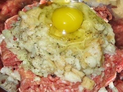 Луковицу мелко режем или пропускаем через мясорубку, хлеб размачиваем в воде, потом отжимаем. Добавляем в фарш, туда же разбиваем яйцо, солим и перчим. Хорошо перемешиваем фарш.