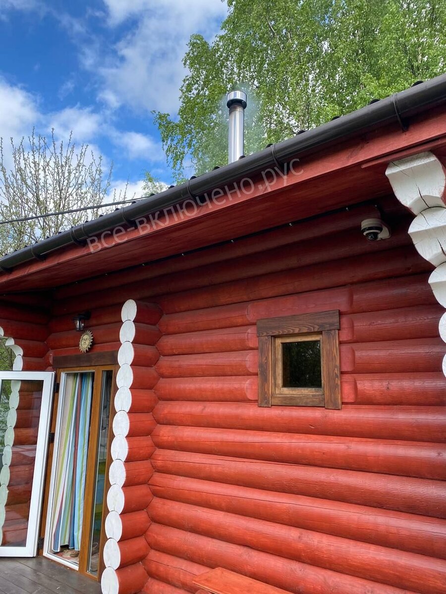 Камера видеонаблюдения HiWatch на стене деревянного дома
