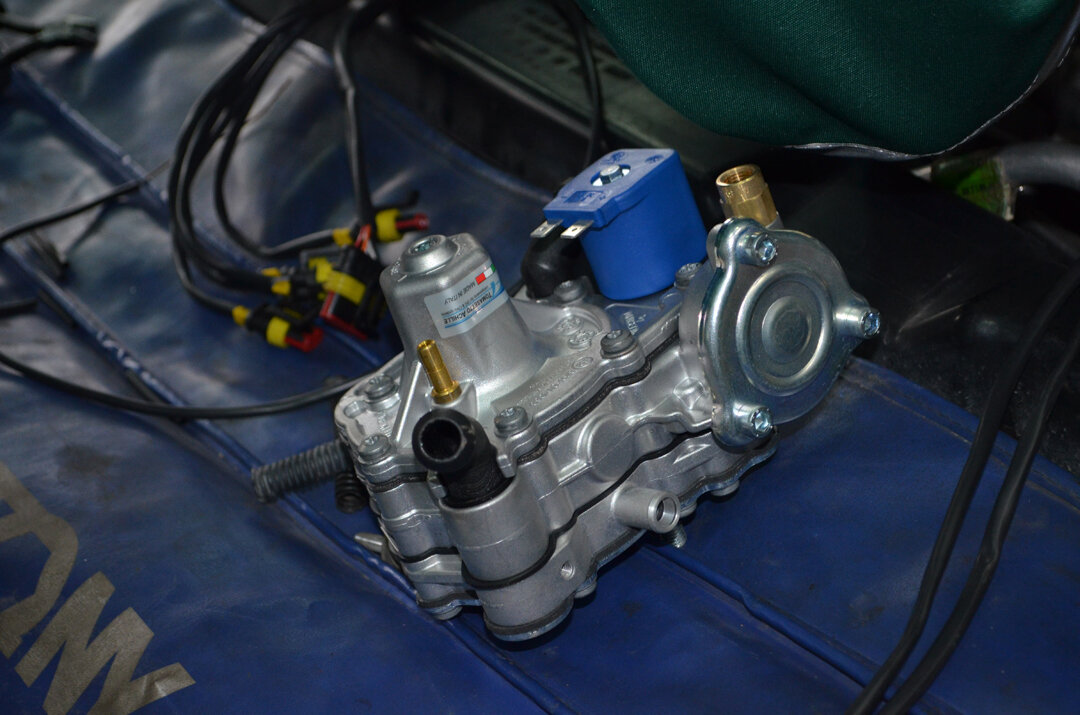 Это – мультиклапан, основа безопасности всего оборудования. У него есть несколько степеней защиты: пожарный клапан (в случае пожара газовый баллон нагревается и может взорваться, чтобы этого не случилось, в открытом огне пожарный клапан расплавляется и начинает вытравливать газ из баллона, сбрасывая давление), клапан аварийного сброса (при повышении давления до 27 бар этот клапан вытравливает газ до нормального давления), электроклапан (в нестандартной ситуации он моментально перекрывает клапан и прекращает подачу газа из баллона), скоростной клапан (на случай обрыва магистралей из баллона до капота, резкое падение давления – он закрывает клапан)