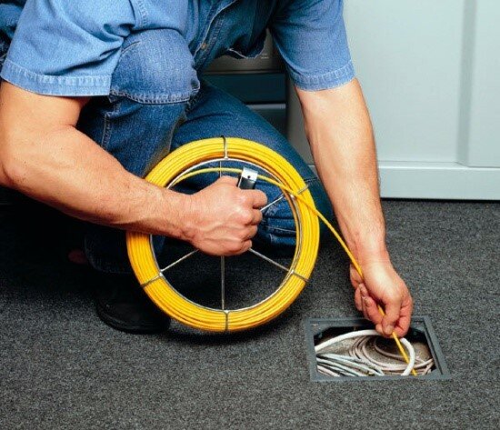 Монтер протягивает кабель с помощью УЗК