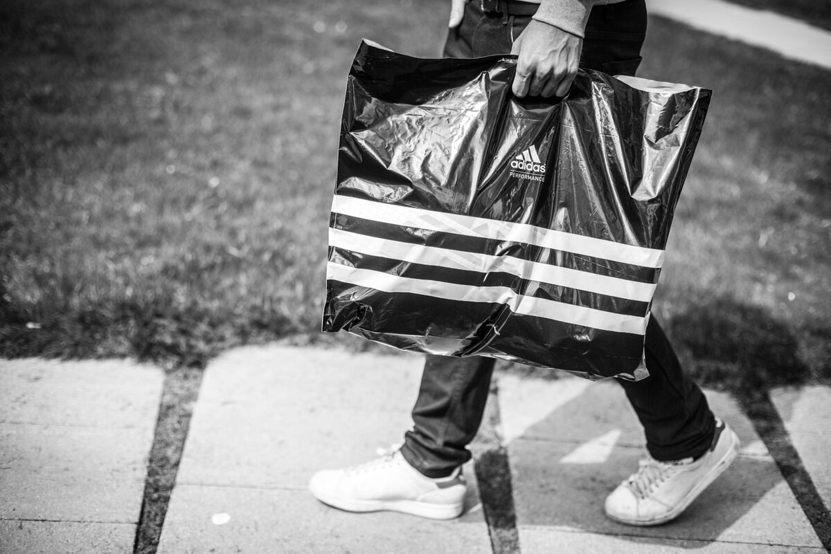 Мужчина с пакетом Adidas