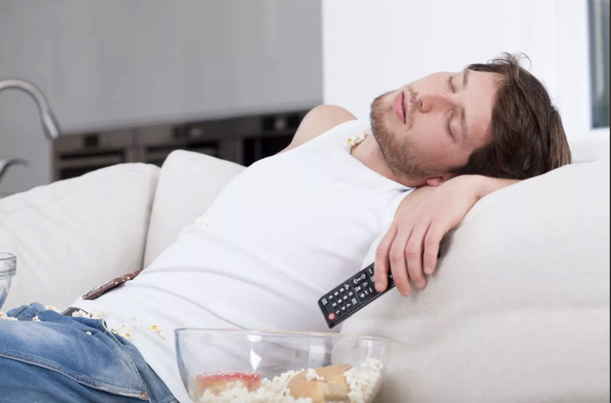 Спать сразу после еды. Ленивый мужчина. Лежание на диване с едой.