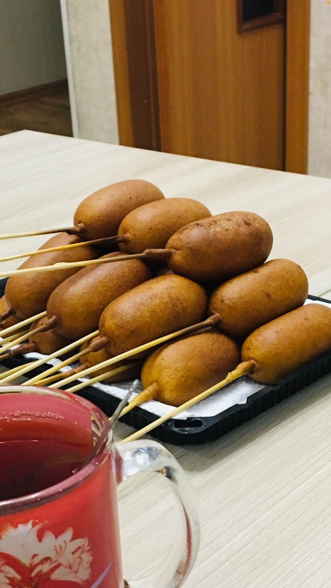 Для начало нужно желательно купить хорошие сосисоны (Хорошие, от этого зависит вкус). растительное масло ( зависит от вашей кастрюли, желательно чем меньше тем лучше) мы готовим в турке, очень удобно и масло мало расходует. Ингредиенты : сосисоны, Мука 1 ст., крупное яйцо, молоко  1/2 ст., разрыхлитель 2ч.л. ( если нету щепотка соды), соль щепотка, сахар 1-2 ст. л. , масло для фритюра.  Смешать в миске все сухие ингредиенты, добавить яйцо и молоко и взбить все миксером или блэндэром. Взбиваем до однородной массы, чтобы на оставалось комочков. 
Масло подогреваем на огне и убавляем огонь на самый минимум. 
Насаживаем сосиски на шпажки ( если сосиски длинные режем пополам). Опускаем сосиску в тесто, даём тесту немного стечь и опускаем в масло. Как только опустили, прокручиваем шпажку пока не образуется корочка, это делаем для того чтобы тесто получилось гладким и расформировалось. Как только корочка подрумянилась достаём из масла и выкладываем на тарелку. В среднем на одну сосиску уходи около 1 минуты. Приятного аппетита 😋 главное не забудьте подписаться ✍🏻 и поставить лайк 👍 