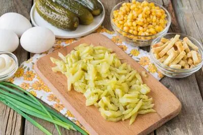 Очистите маринованные огурцы от кожицы, нарежьте длинными, умеренно тонкими брусочками и слегка отожмите от рассола.