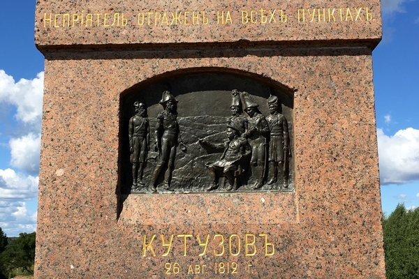 Главнокомандующий сидит на скамейке в расстегнутом сюртуке и кавалергардской фуражной шапке, с картой на коленях. За его спиной стоят (слева направо): начальник штаба 1-й армии генерал-майор А. П. Ермолов, полковник К. Ф. Толь и командир отдельного казачьего корпуса генерал от кавалерии М. И. Платов. Перед Кутузовым - генерал М. Б. Барклай-де-Толли, за ним — казак.