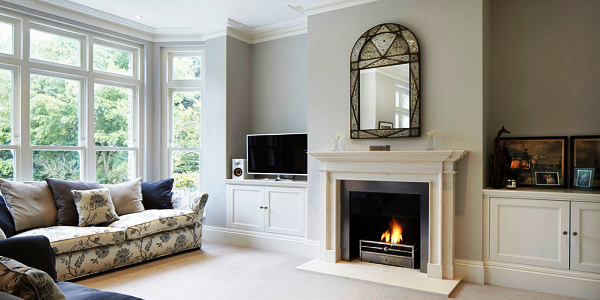 Биокамин в портале из МДФ – недорогой и стильный вариант для современной классики. Лаконичная резьба удачно сочетается со «старинным» зеркалом, а черный очаг – с ТВ.