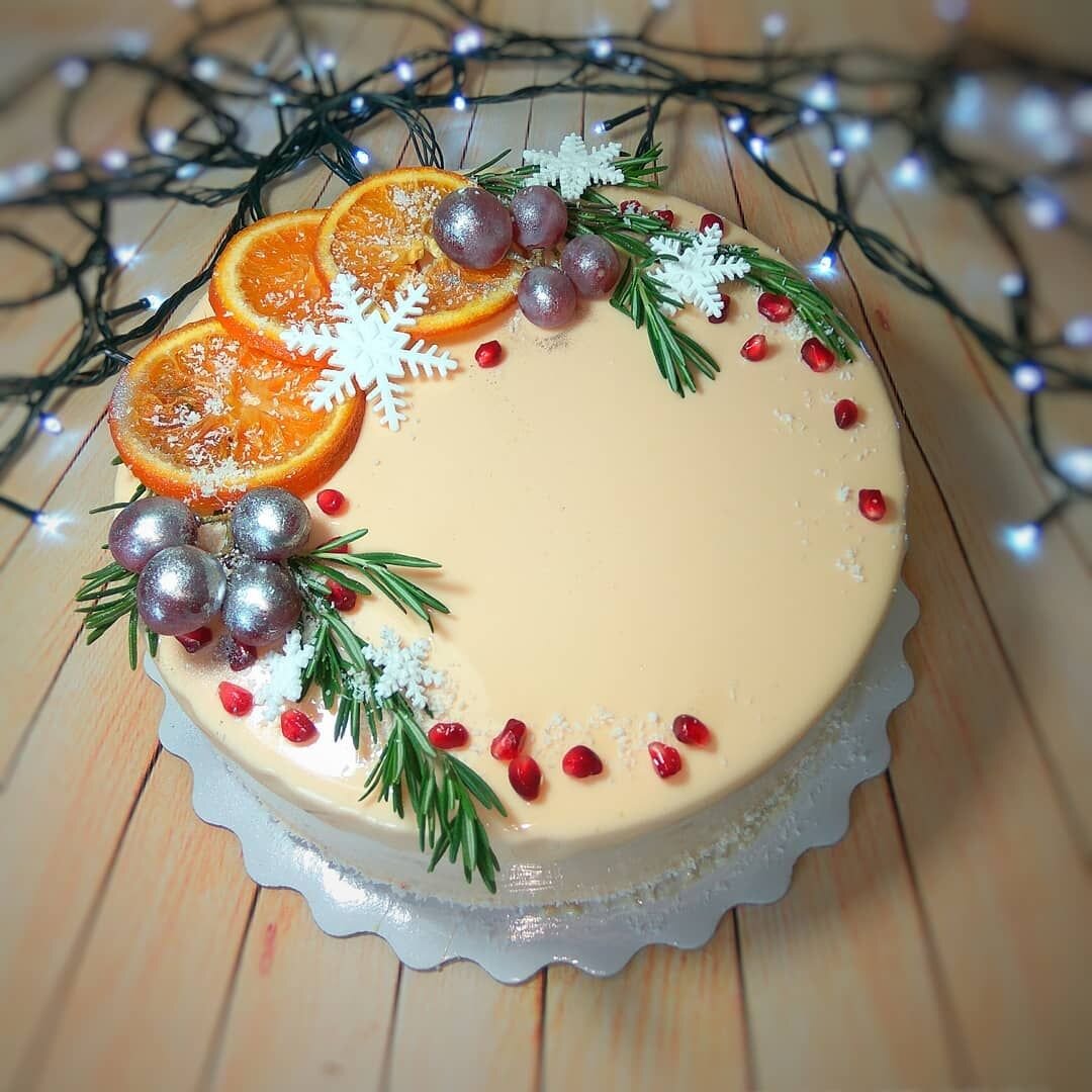 Торт на Новый год украшенный фруктами и фигуркой елки