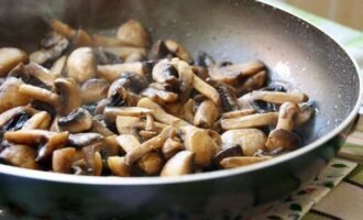 Промойте грибы в прохладной воде. Высушите их на салфетке. В раскалённую сковороду налейте масло и отправьте туда один гриб нарезанный брусочком. Обжарьте его с двух сторон. По позже он нам понадобиться для украшения.
Нарежьте все грибы полукольцами и обжарьте с двух сторон на среднем огне 20 минут.