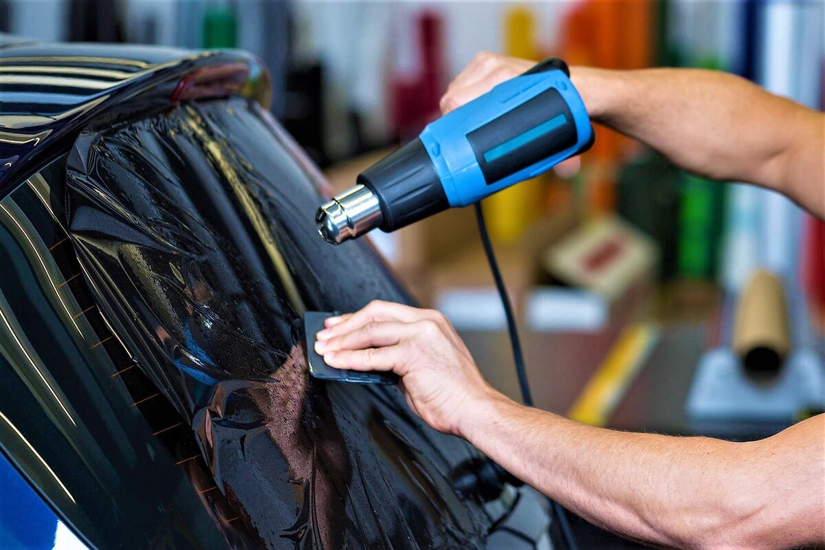 мастер разглаживает тонирующую пленку