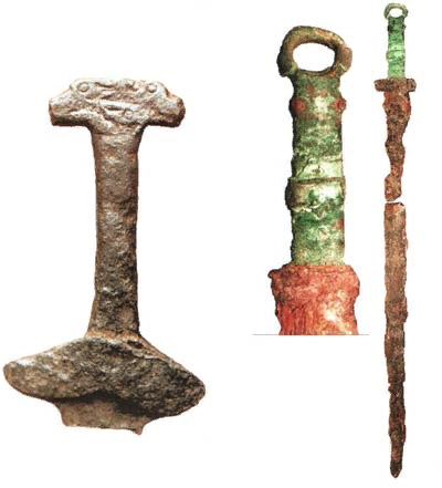 Слева - эфес саргатского меча с характерным украшением. Справа - намеренно переломленный клинок, положенный в могилу воина. Оба меча железные.