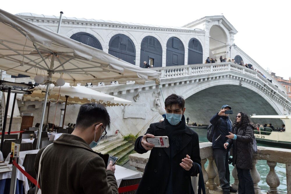 Туристы перед мостом Риальто в Венеции, Италия, 24 февраля. Андреа Паттаро / AFP / Getty.