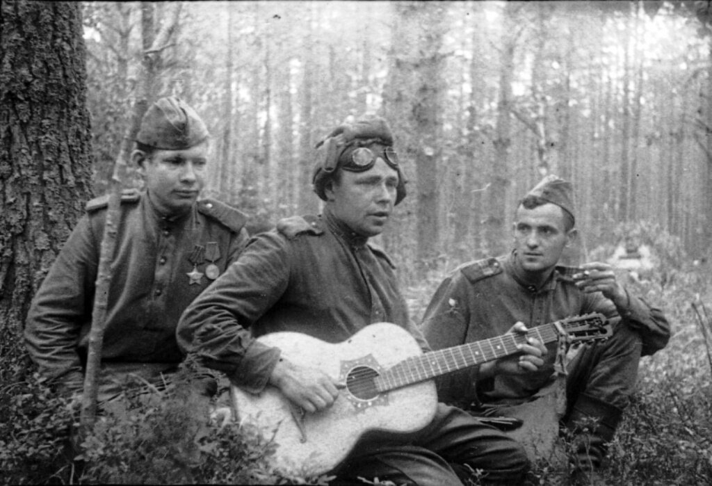 Советские бойцы слушают своего товарища, играющего на гитаре. 1-й Белорусский фронт (источник: https://smolbattle.ru/data/attachments/527/527162-4d6b2e305bc64b78eadbcf191bc91467.jpg)