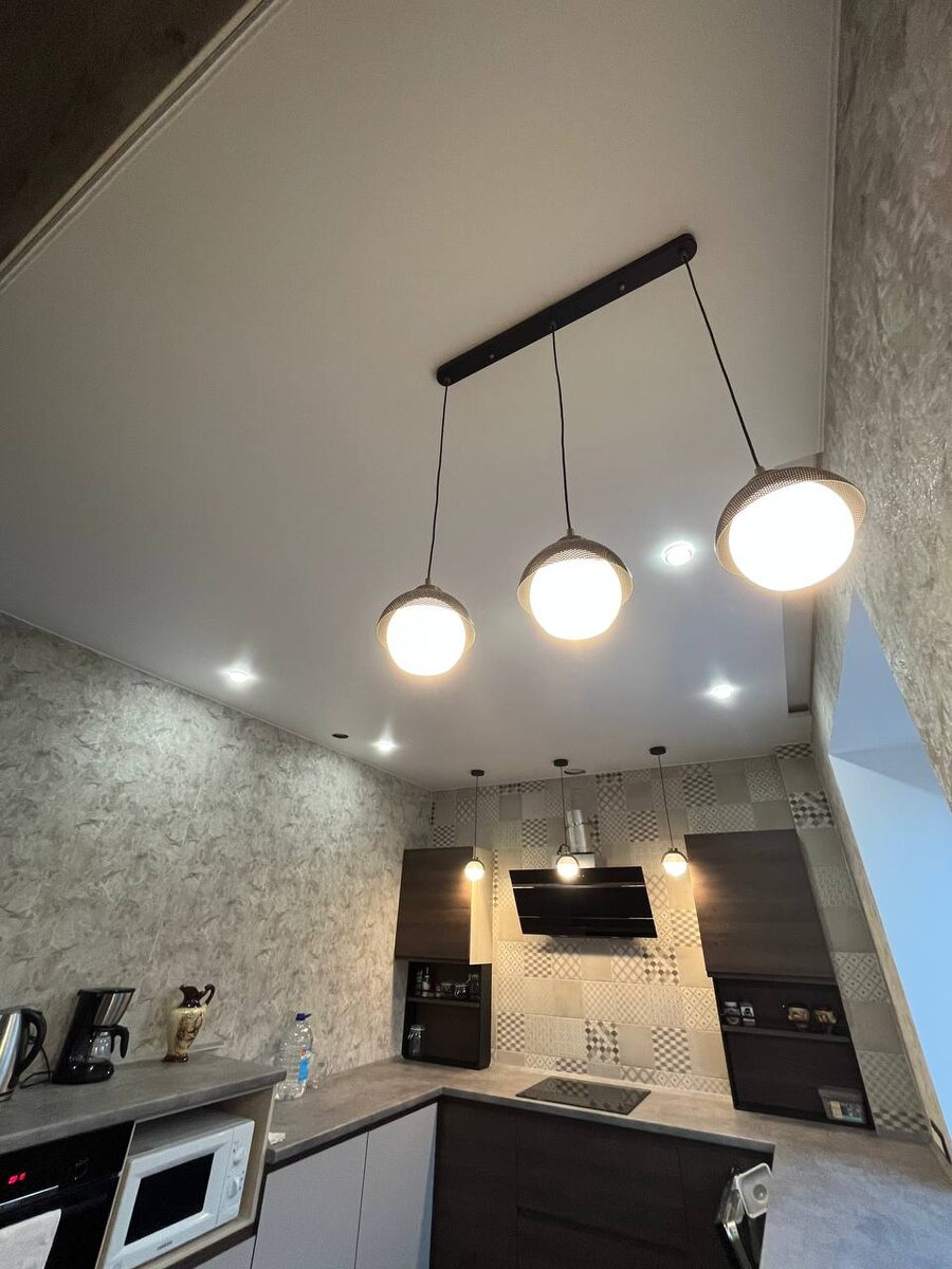 На фото натяжной потолок с точечными светильниками на кухне