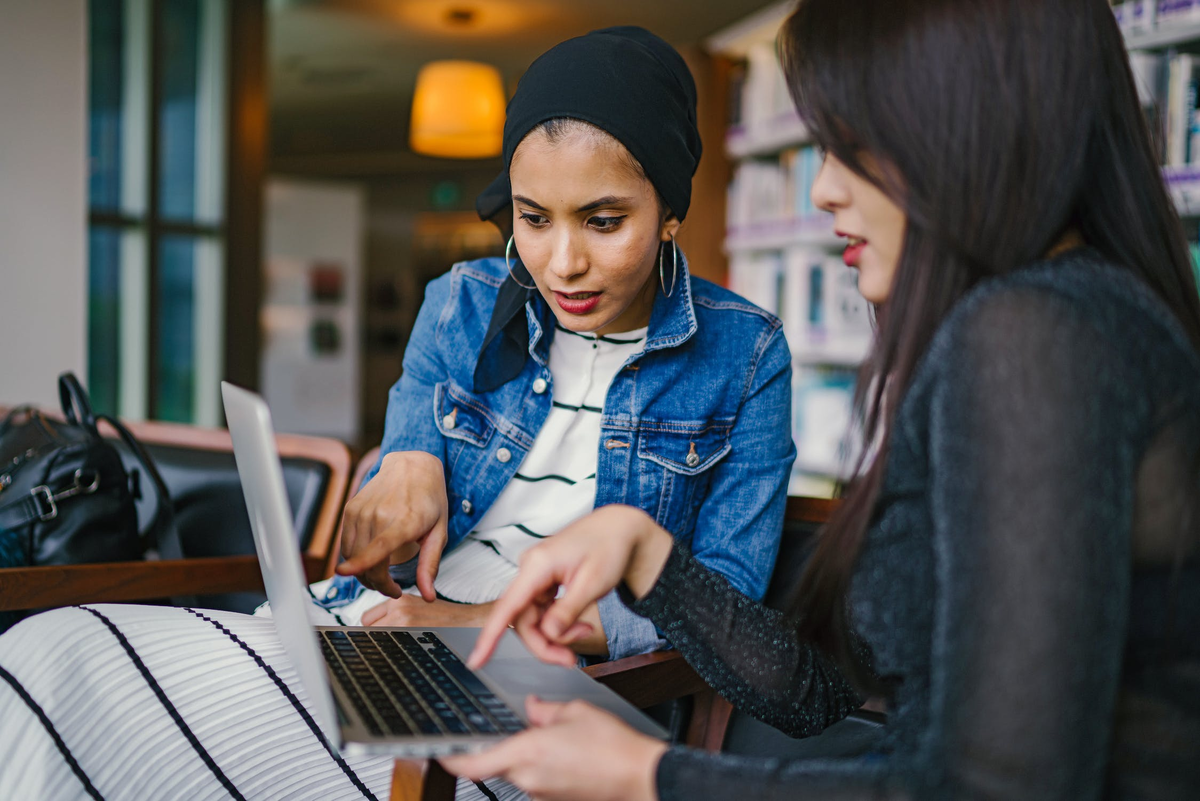 pexels.com/photo/two-women-looking-and-pointing-at-macbook-laptop-1569076/