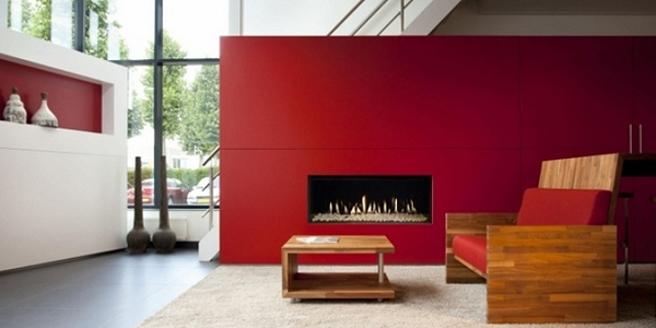 Красный портал под биокамин смотрится ближе и меньше реальных габаритов. Поэтому яркая цельная стена хороша для длинных узких помещений. С ней короткий торец комнаты зрительно «приблизится» без перепланировки.