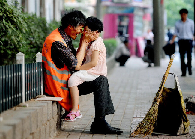 Дворник Чжан Цзинхэ (счастливый дворник) на улице наслаждается счастливыми мгновениями со своей внучкой Чжан Синь