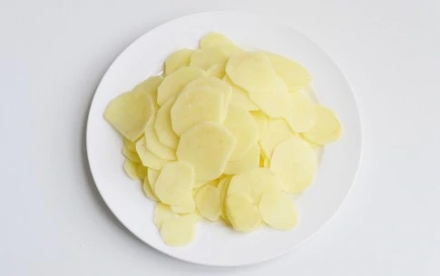 1. Нарежьте картошку тонкими пластинами и отварите.