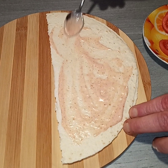 Можем свёрнутую пополам тортилью только что приготовленной намазкой