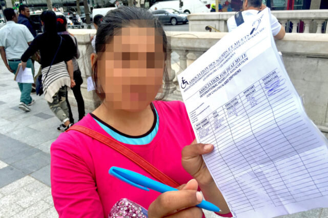 Девушка предлагает подписать петицию в центре Парижа.