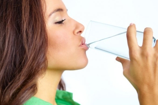 Девушка пьет воду.