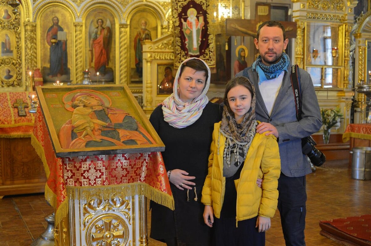  Олег Зон вместе с семьёй во время посещения Никольского храма в Солнечногорске. Рядом - его работа "Взыскание погибших"
