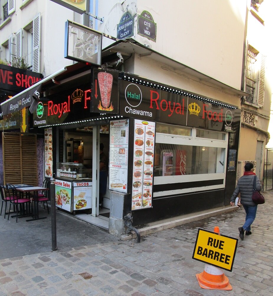 Арабские шаверма и халяль на бульваре Клиши в Париже. У французов есть даже такое выражение - "араб на углу". Это магазинчик мелких торговцев-иммигрантов, который работает во внеурочное время, когда все приличные буржуа, владельцы и сотрудники  сетевых супермаркетов или одиночных бутиков давно отдыхают или спят. В Германии их роль выполняют турки, в Великобритании - индийцы. Без них даже купить сигареты в выходные - большая проблема.