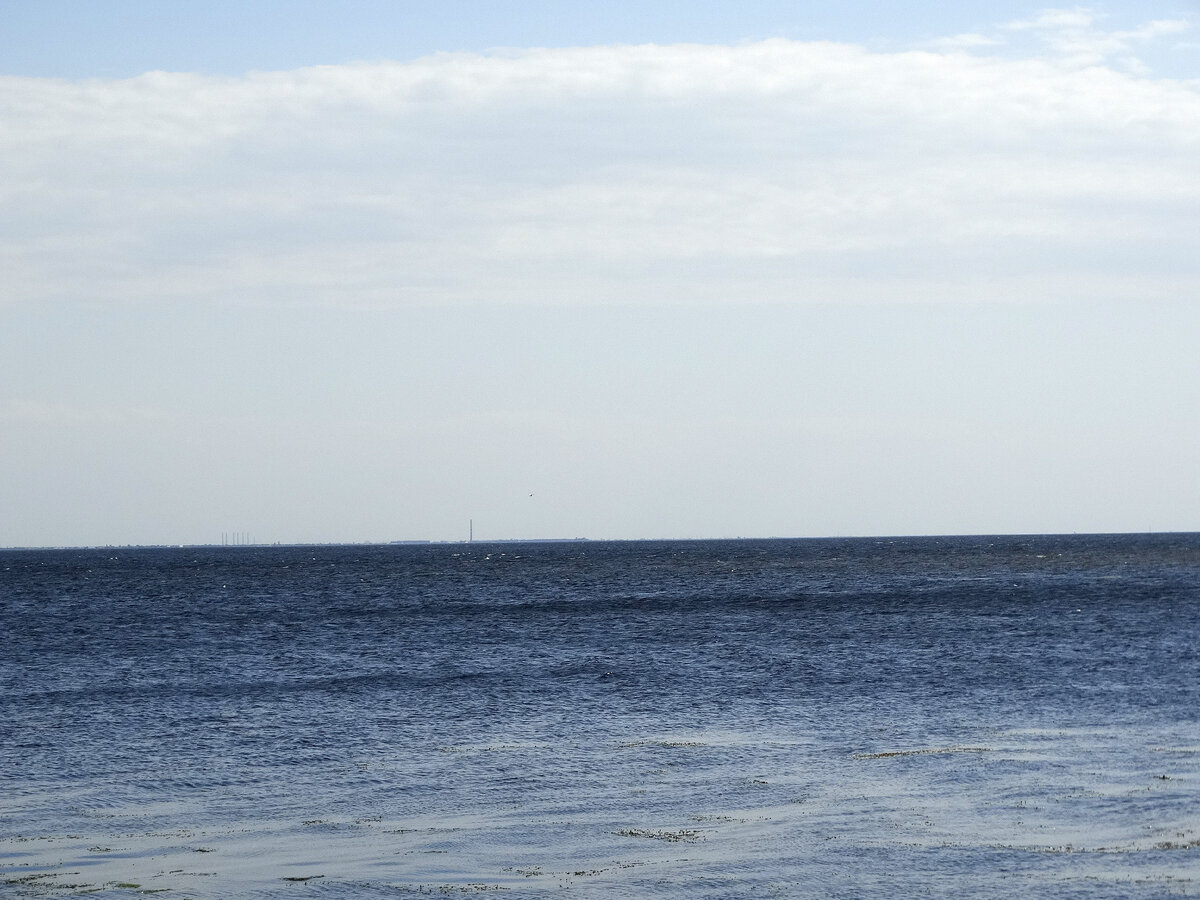 Чем не море? Собственно это оно и есть, только рукотворное. На горизонте видны трубы промзоны Волжского. Звучит невероятно. От Дубовки до Волжского по прямой около 26 километров. Но на противоположном берегу водохранилища нет других населённых пунктов с такими высокими трубами, только город Волжский. Слева по линии горизонта видны шесть близко стоящих труб. Если не ошибаюсь, это трубы волжского абразивного завода.