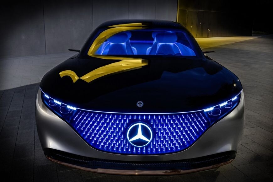  Электрокар Mercedes-Benz Vision EQS  неуловимо напоминает фильмы о далеком будущем – особенно в темноте,  когда включается синяя подсветка. Vision EQS оснащен батареей 100 кВт/ч.  Общая мощность новинки – 476 «лошадей», запас хода - 700 километров.  Электродвигатели в этой модели расположены как спереди, так и сзади. В  совокупности с встроенной в пол аккумуляторной батареей они составляют  полноприводную электрическую систему с регулируемым по оси  распределением крутящего момента. Любителей дальних дорог порадует  система автономного вождения третьего уровня.
Фары Digital Light оснащены двумя  модулями голографических линз. На задней части вместо стоп-сигналов  установлены 229 звезд, а передняя решетка дополнена световой матрицей из  188 светодиодов, дающих 3D- эффект.
В дизайне салона используются крышки  динамиков из розового золота, флакон с ароматом, заключенный в  декоративный держатель и высококачественная кристально-белая микрофибра  DINAMICA с оригинальной фигурной отделкой из клена.