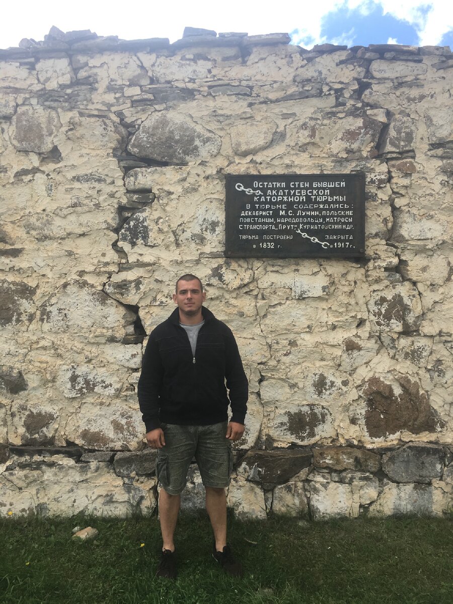 На фоне руин.