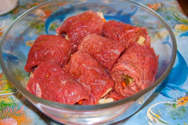 Для начинки используем овощи на ваш вкус. Картофель, морковь и лук очистить, порезать крупной соломкой. Положить начинку на каждый кусочек мяса (по желанию можно добавить соленый огурец), скрутить рулетом. Плотно уложить в жаропрочную форму.